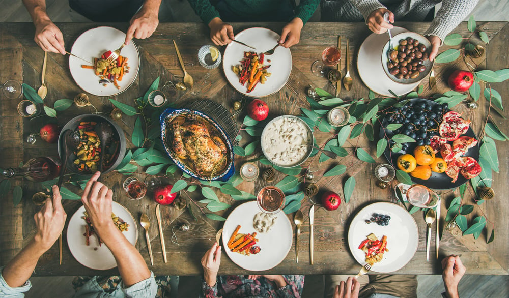 Friends or family eating at festive Christmas table, top view